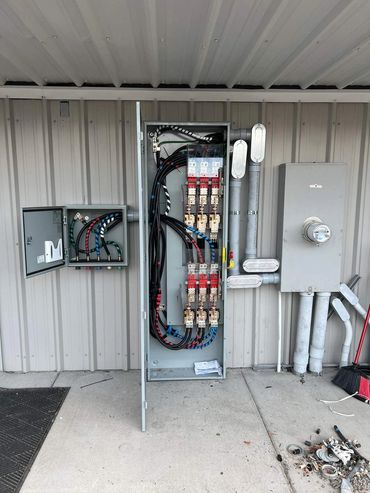 Commercial generator transfer equipment and disconnects on a metal building wall