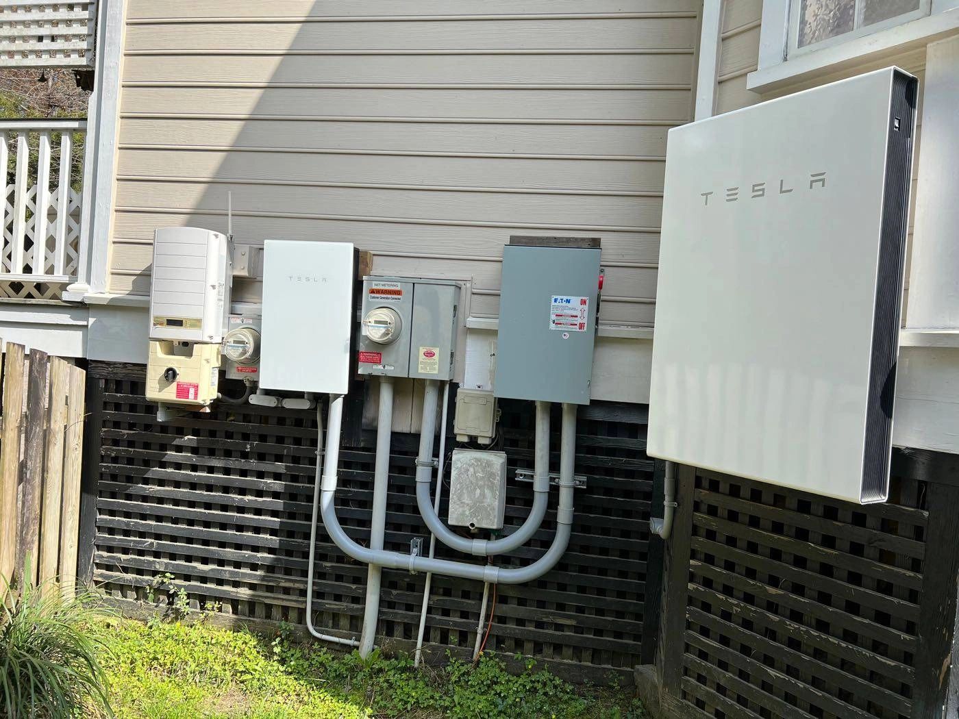 Tesla Powerwall, SolarEdge inverter, and utility meters on a house exterior