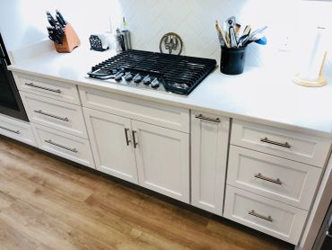 Modern kitchen countertop with gas stove and utensils.