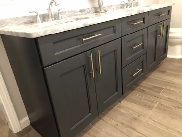 Modern bathroom vanity with dark cabinets and marble countertop.