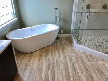 Modern bathroom with a white freestanding tub and glass shower.