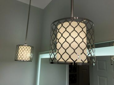 Modern pendant lights with patterned metal shades illuminating a room.