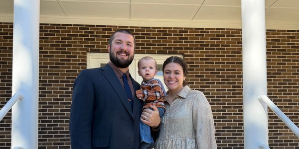 A happy family posing on porch steps.