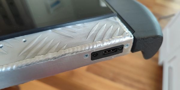 Close-up of a device with a metal frame, HDMI port, and black plastic corner.