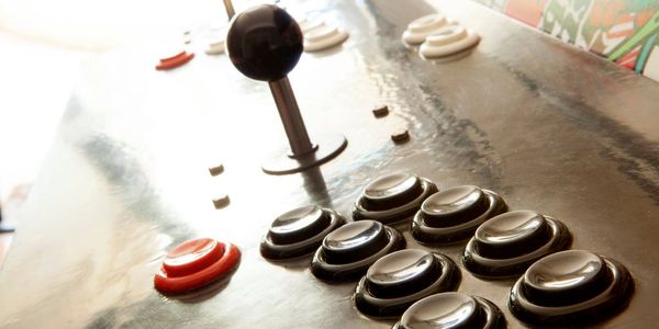 Close-up of an arcade game joystick and buttons.