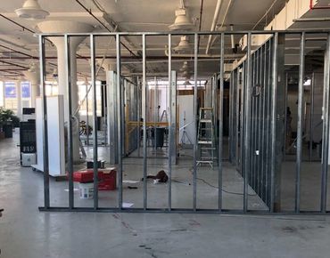 Interior of a building under construction with metal framing and ladders. Kitchener offices