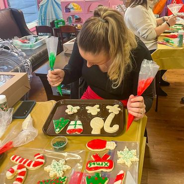 Woman decorating Christmas sugar cookies