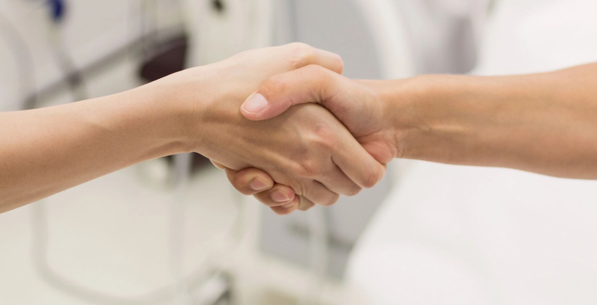 1 female hand-shaking a male nurse's hand