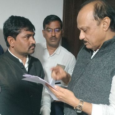Three men engaged in a serious discussion over documents.