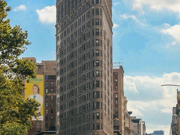 Wide angle view of the Flatiron. The Flatiron Building, originally the Fuller Building, is a triangular 22-story, 285-foot tall steel-framed landmarked building located at 175 Fifth Avenue in the Flatiron District neighborhood of the borough of Manhattan, New York City