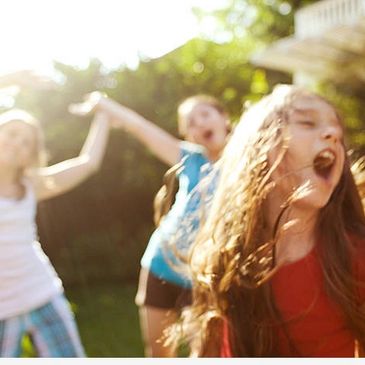 Children joyfully playing outdoors on a sunny day.