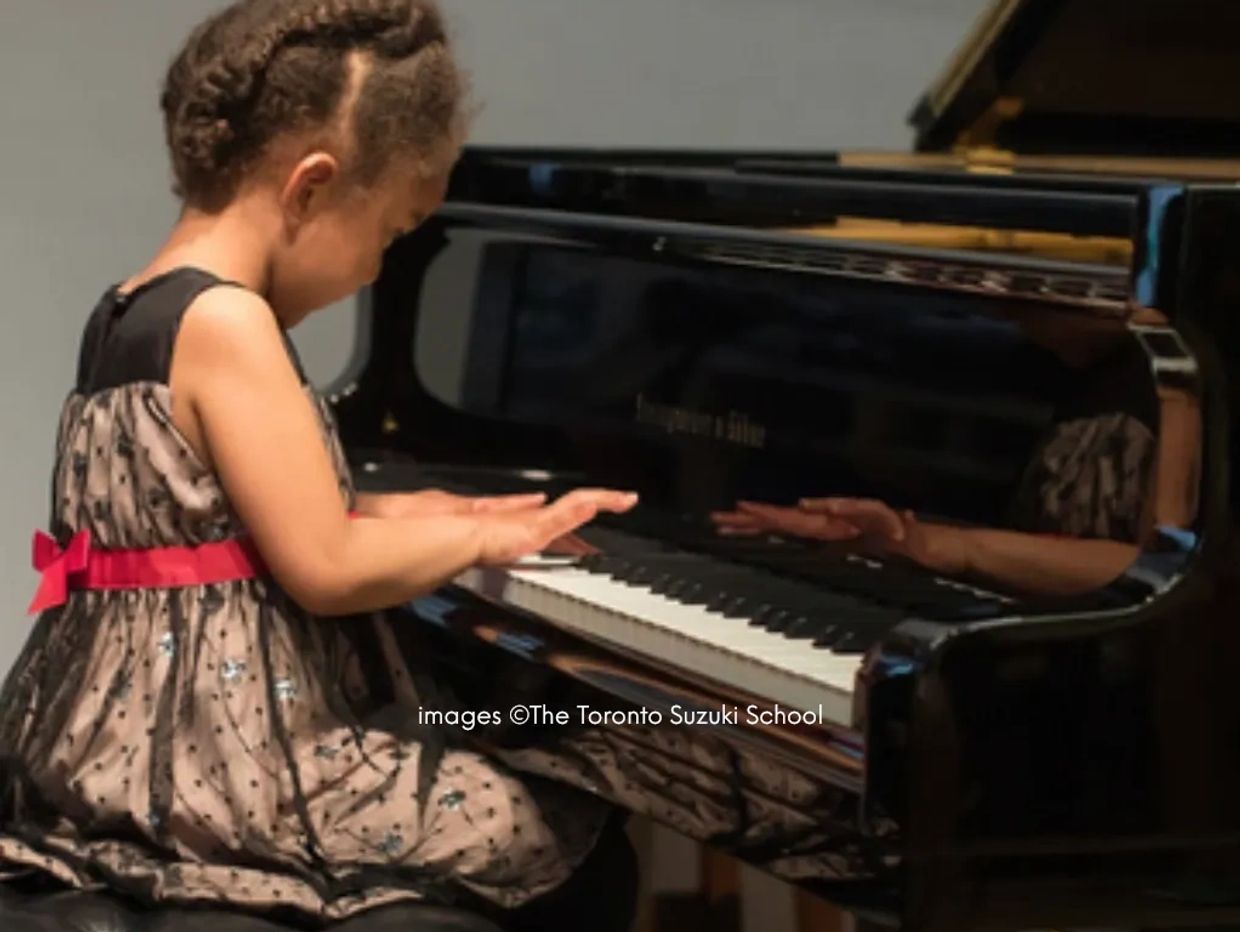 Young girl playing piano with focus and joy.