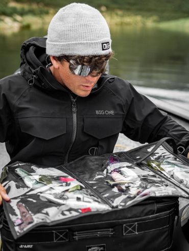 Pescatore che organizza esche artificiali in barca prima della sessione di pesca.