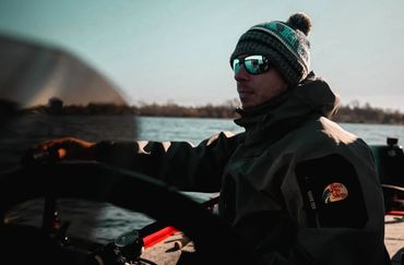 Ritratto outdoor di persona in barca durante attività di pesca sportiva.