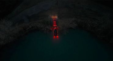 Ripresa con drone di un fuoristrada parcheggiato vicino all’acqua al tramonto, in un ambiente naturale isolato.