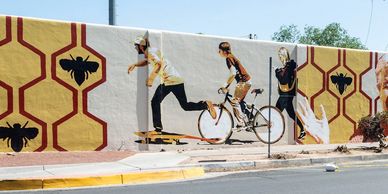 A restored mural in the University Heights neighborhood with outlines of bees and portraits.