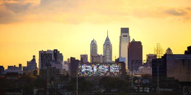 Image of a mural with the word RISE against the Philadelphia skyline.