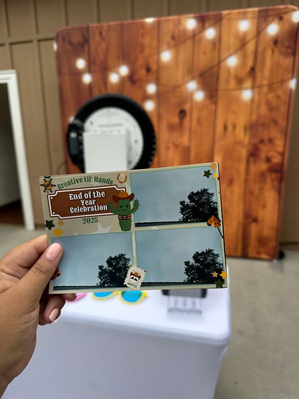 Hand holding a photo booth print from a 2025 end-of-year celebration event.