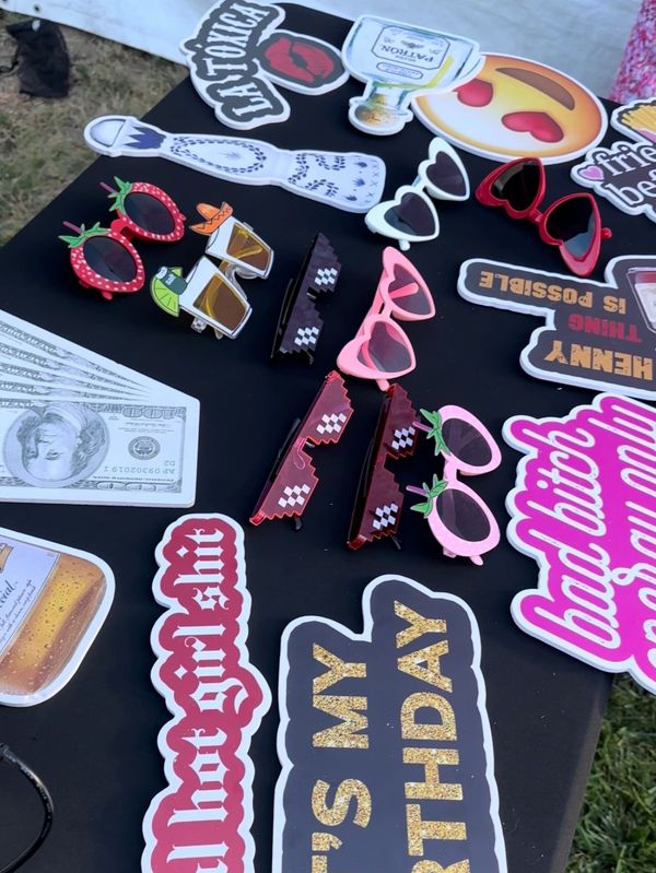 Birthday-themed props and fun sunglasses on a black table.