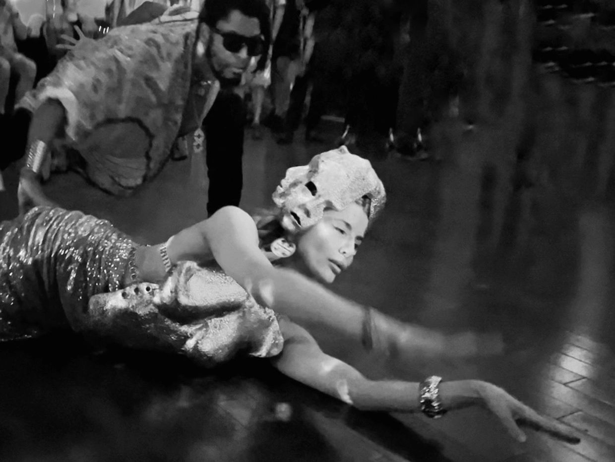Danseur allongé avec un masque, une autre personne observe.