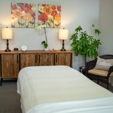 Cozy massage room with floral decor and soft lighting.