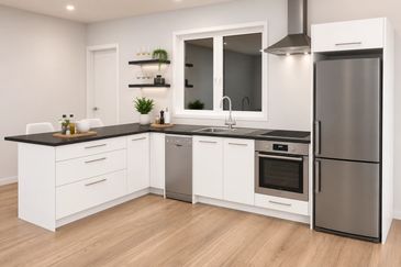 Modern white kitchen with stainless steel appliances and wooden floor.