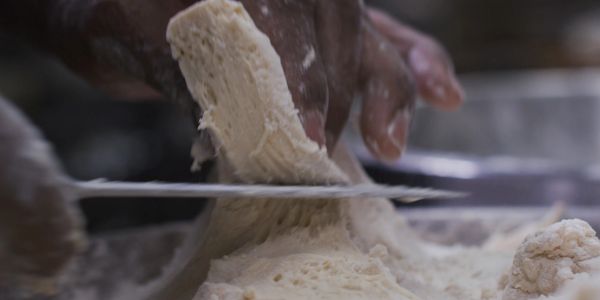 Hand cutting dough with a knife.