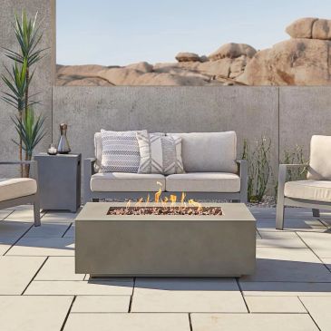 Modern outdoor seating area with fire pit and desert backdrop.