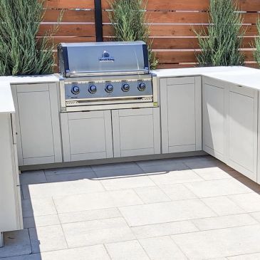 Modern outdoor kitchen with built-in stainless steel grill.