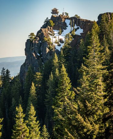fire tower in the pacific northwest sitting a top a tall mountain in winter. snow and pine trees