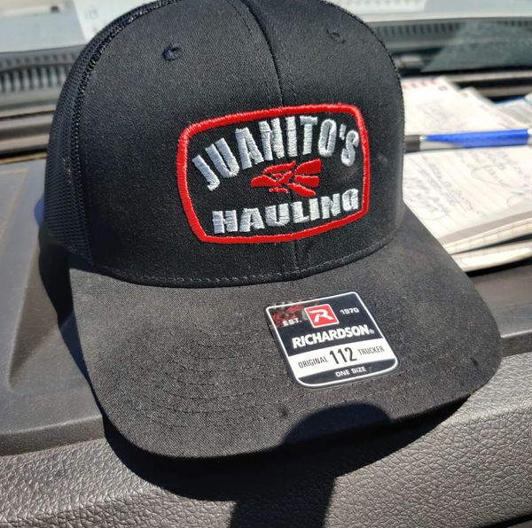 Black trucker hat with Juanito's Hauling logo.