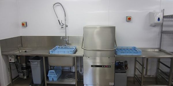 Stainless steel wash up area with hood dishwasher and sink