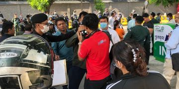 Authorities grab a camera during a protest outside the Chinese Embassy in Phnom Penh in October 2020