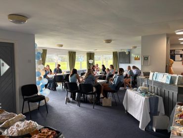 People gathered in a room for a social event with food and decorations.
