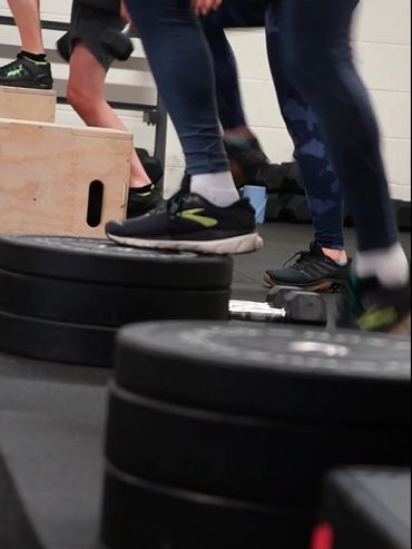 People exercising with weights and steps in a gym setting.