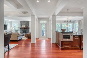 Bright open home with wood floors, stone fireplace, and modern kitchen.