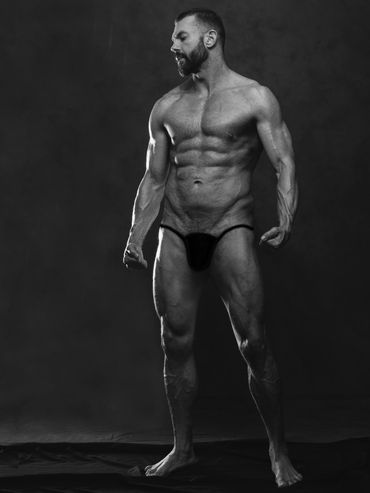 Body builder's portrait in black and white on gray background
