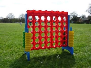 A giant outdoor Connect Four game set on a grassy field.