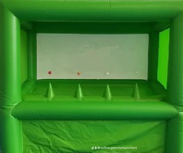 Green inflatable carnival game with cones and balls inside.