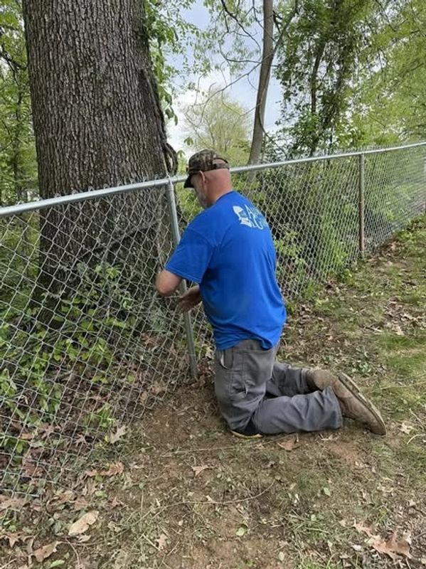 Fence professional Ronald Willis tying in a chain-link fence in Newburgh, Indiana.