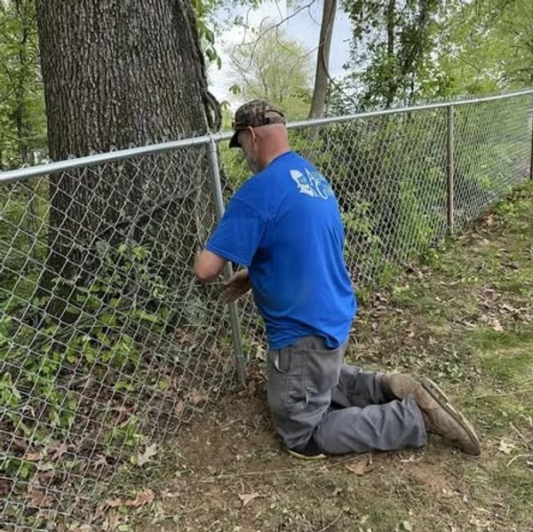Fence professional Ronald Willis tieing in a chain-link fence in Newburgh, Indiana.