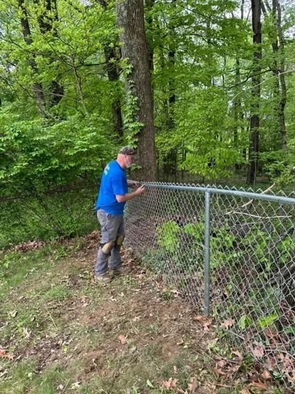 Fence professional Ronald Willis of Willis Outdoors LLC replaces a damaged chain-link fence