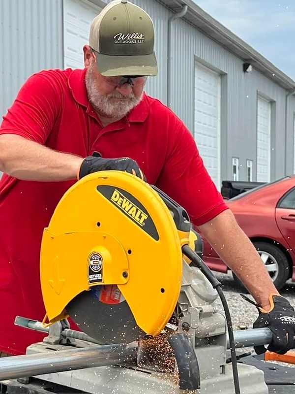 Willis Outdoors LLC in Newburgh, Indiana fence repair specialist cutting pipe into posts.