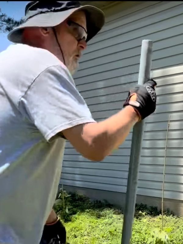 Ronald Willis, fence repair specialist removing chain link fence posts in Newburgh, Indiana