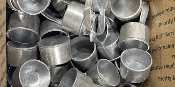 A box filled with small metal cups with handles.