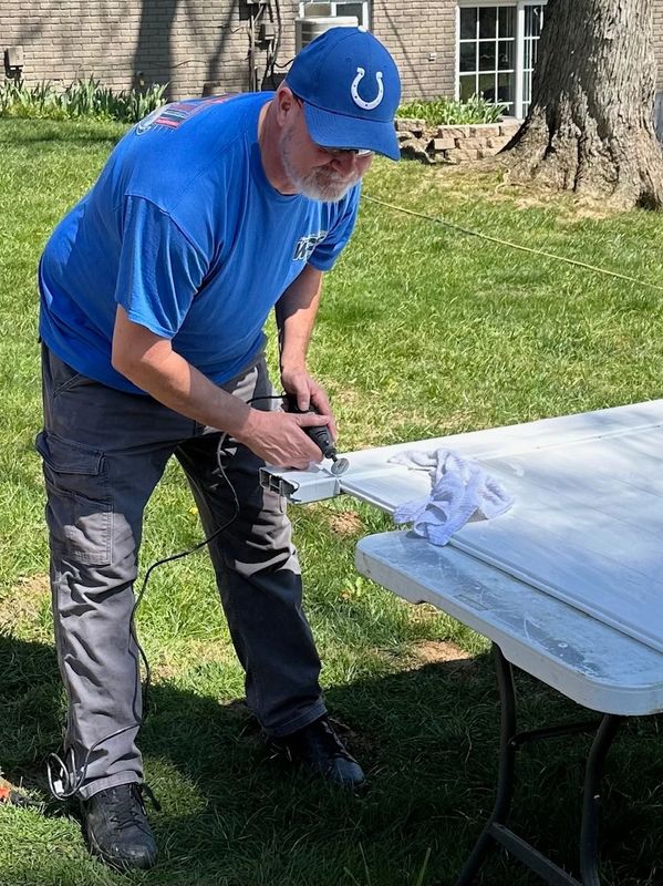 Fence professional Ronald Willis of Willis Outdoors LLC repairs a damaged PVC gate