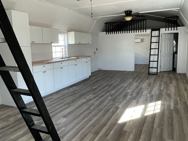 Finished in white bead board, weathered wood vinyl, white cabinets with butcher block counters.