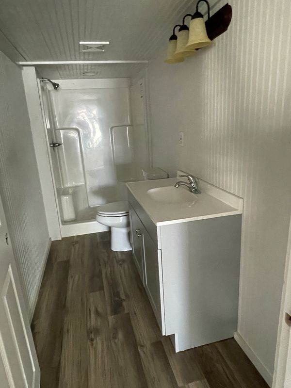 Walk in shower and 36" vanity in gray make this bathroom feel large.