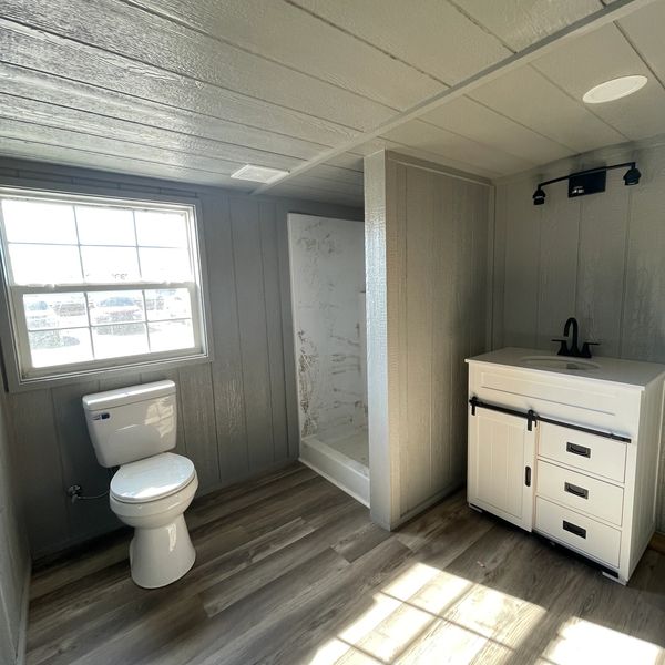 Barn style vanity and 3'x3' walk in shower make for a stunning layout in this bathroom.