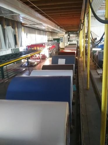 Industrial rolls of material lined up in a factory setting.